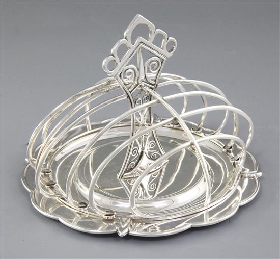 A good George V Arts & Crafts silver seven bar toast rack, Diameter :7 ¼”/183mm Height 5 ¼”/135mm Weight: 17.2oz/487grms